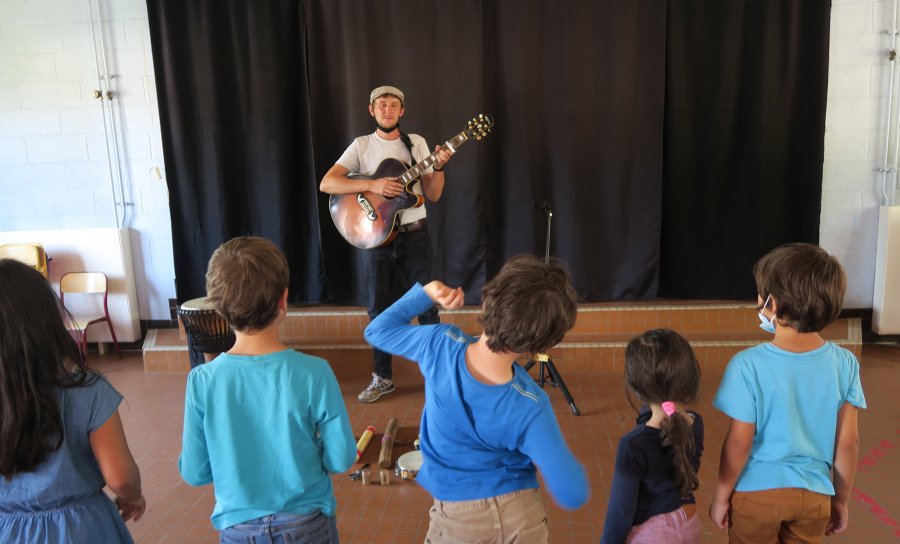Le musicien Étienne Obry joue de la guitare lors d'un atelier à Jouy-Le-Moutier