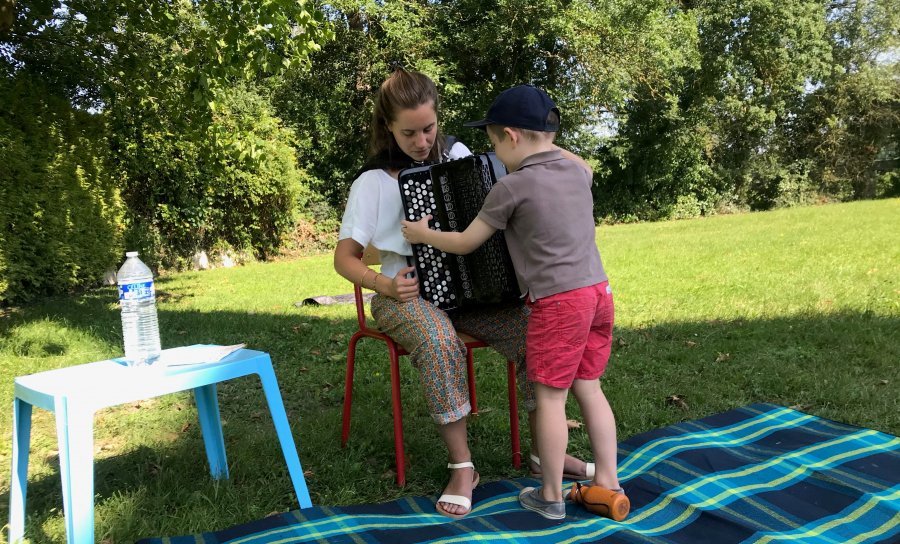 L'accordéoniste Sophie Aupied montre son instrument à un enfant