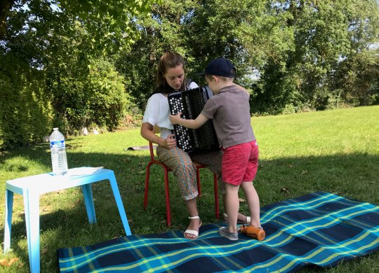 Musicienne qui montre son accordéon à un enfant